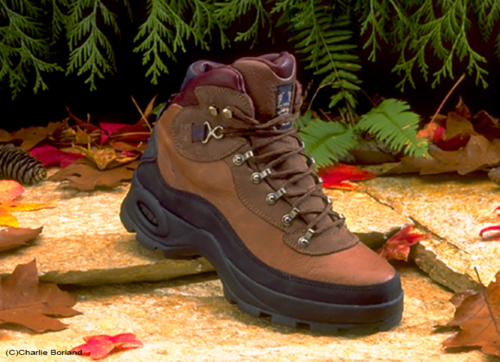 A product photography photoshoot of a hiking shoe against a natural background